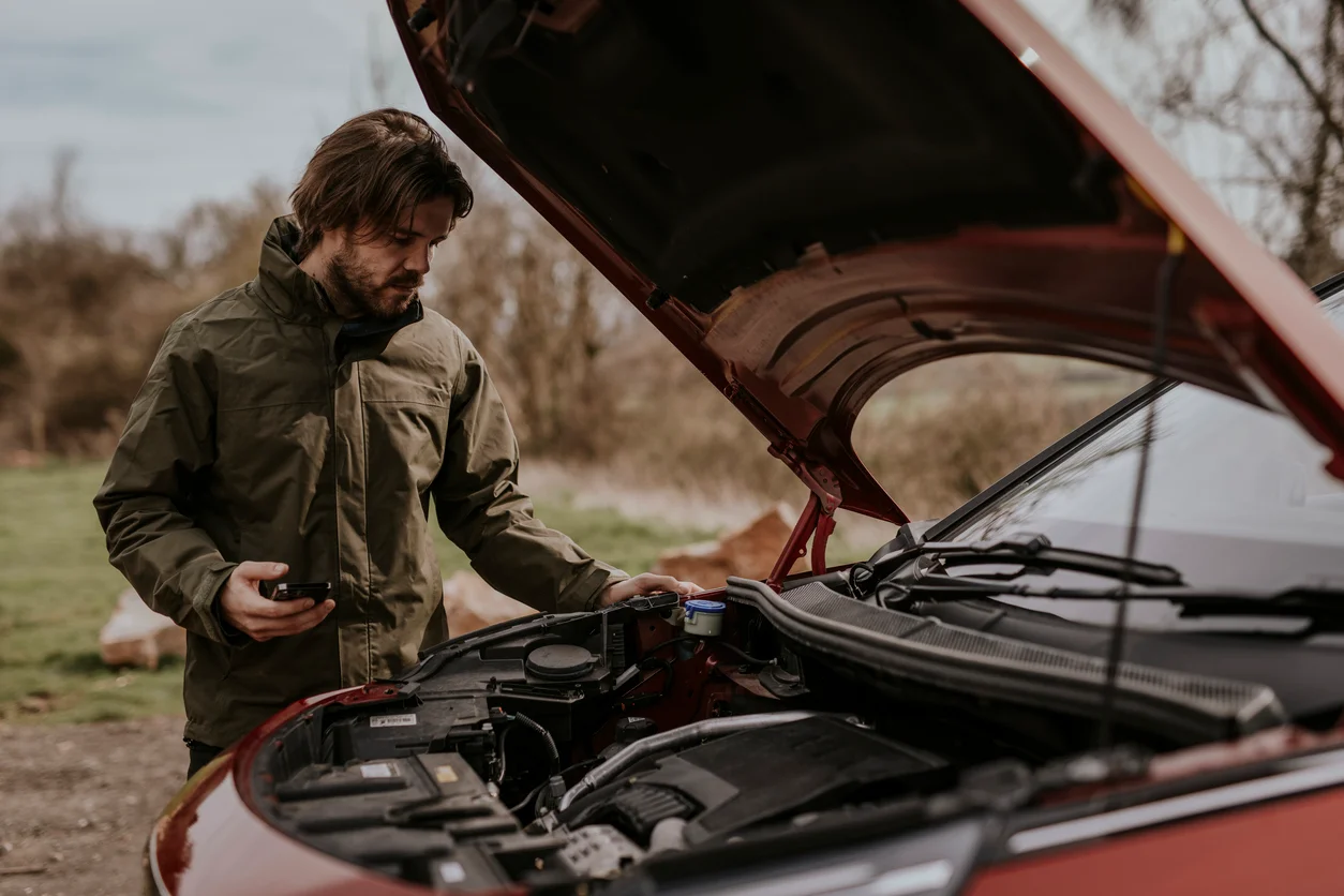 Emergency car repair scenario showing a mechanic working on a vehicle