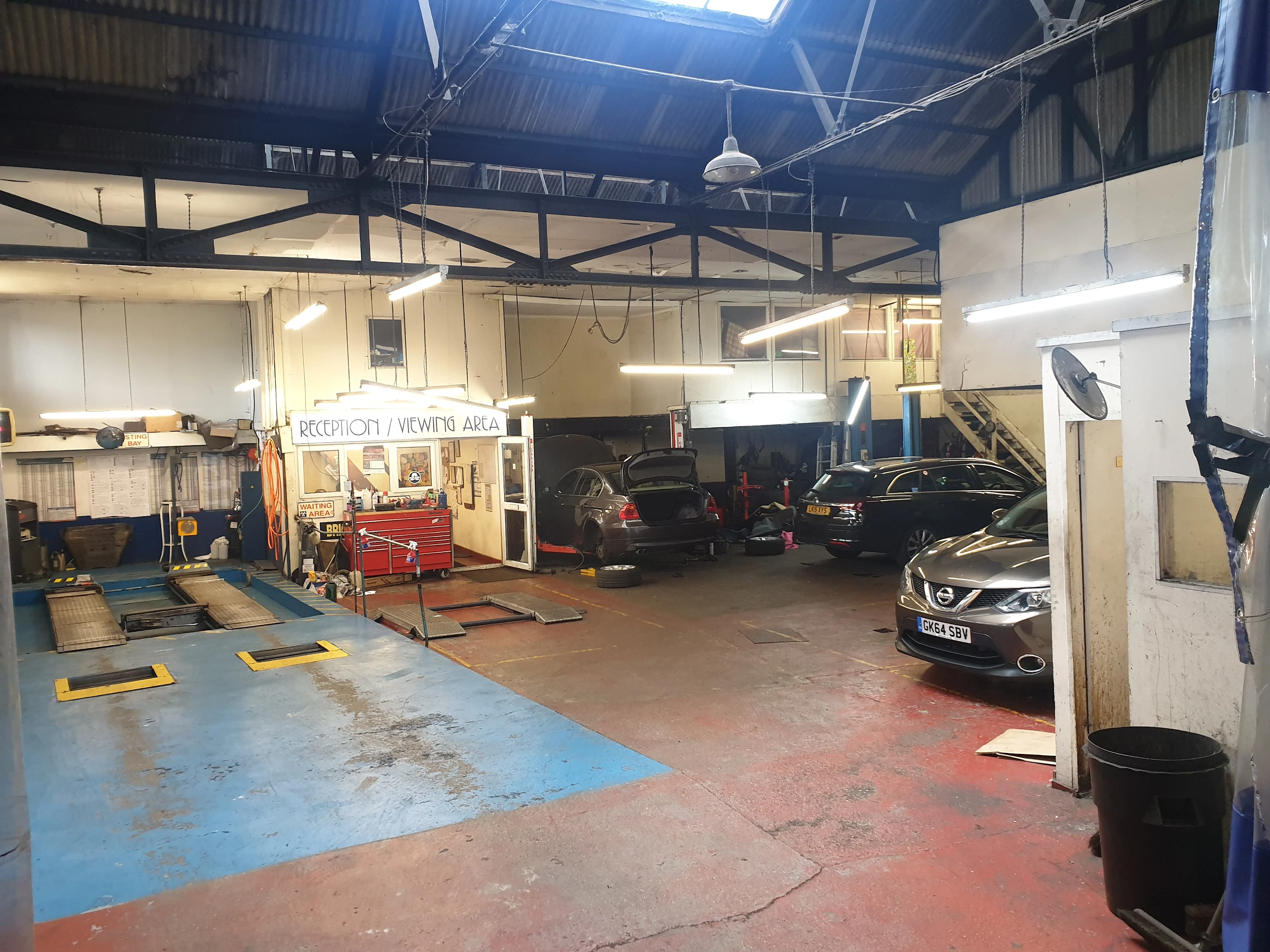 Brighton MOT testing center with vehicles being tested and Brighton cityscape in background