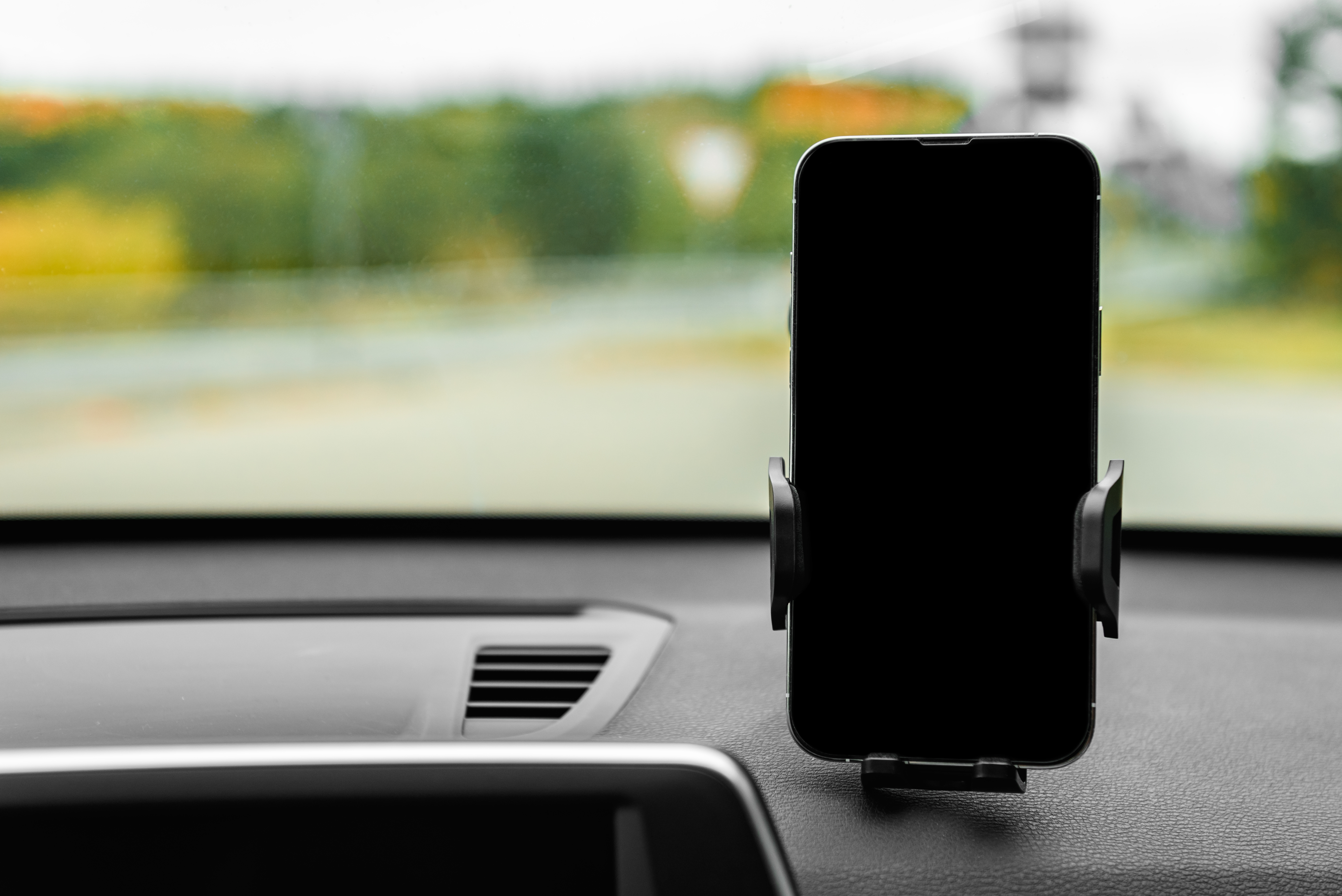 Car phone holder mounted on dashboard showing navigation for UK drivers